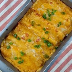 a casserole with cheese and green onions in a pan on a striped cloth