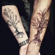 two people holding hands with tattoos on their arms and the other hand has a tree