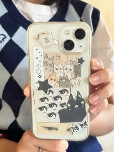 a woman holding up an iphone case with cats and stars on it