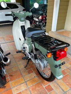 two motorcycles parked next to each other on a brick floor