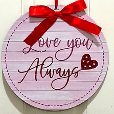 a sign that says love you always hanging on a door with a red ribbon around it