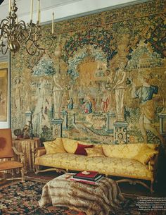 a living room filled with furniture and a tapestry on the wall