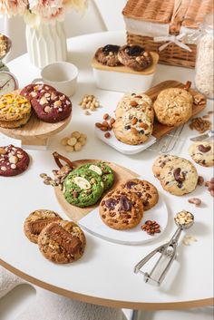 a table topped with lots of cookies and muffins