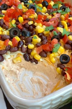 a casserole dish with black olives, corn and tomatoes