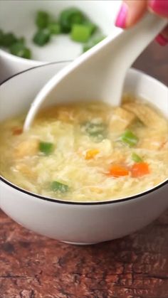 a white bowl filled with soup sitting on top of a wooden table