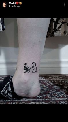 a person's foot with a small tattoo of a dog pushing a shopping cart