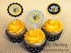 three cupcakes with yellow frosting and bee toppers on polka dot paper