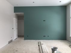 an empty room with green walls and white trim