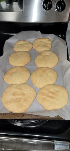 some food is sitting on top of wax paper in front of an oven with the door open