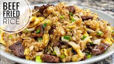 beef fried rice on a plate with onions and green onions in the foreground text overlay reads beef fried rice rice