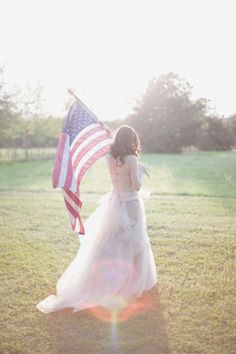 a woman in a white dress holding an american flag