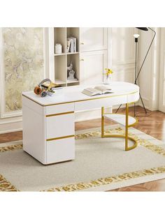 a white desk with gold trimmings and a book shelf in the corner next to it