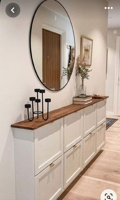 a room with white cabinets and a round mirror on the wall