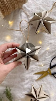 someone is holding some origami stars on a table with string and twine