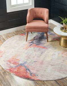 a chair sitting on top of a wooden floor next to a rug with an abstract design