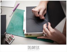 a woman is working on some crafting projects with scissors and thread in her hand