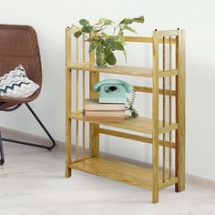 a wooden shelf next to a chair with a phone on it and a potted plant