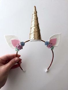 someone is trying to make a unicorn headband out of paper and gold glitters