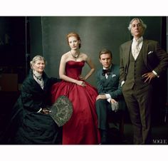 three people are posing for a photo in formal wear and one is wearing a red dress