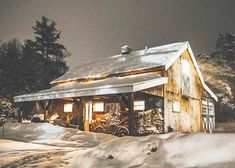 a barn in the middle of winter with snow on the ground