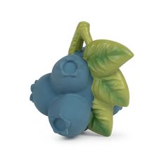 a small blue and green toy with leaves on it's back end, sitting in front of a white background