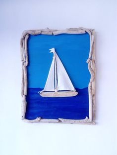 a white sailboat floating in the ocean on a blue and white background with driftwood frame