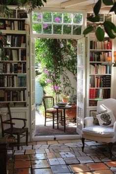 a living room filled with lots of furniture and bookshelves next to a doorway