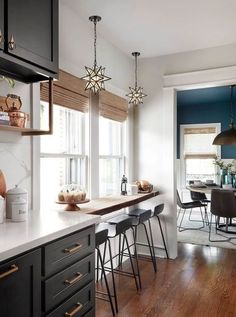 a kitchen with wooden floors and black cabinets