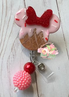 a red and white keychain with a heart shaped cake on it's side