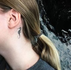 a close up of a person with a tattoo on their neck and behind her ear