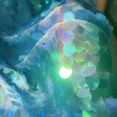 an abstract photograph of blue and green bubbles in the water with sunlight shining through them