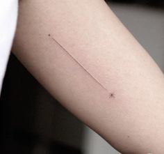 a person's arm with a tiny star tattoo on the left side of their arm