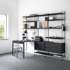 a black and white room with two desks, bookshelves and shelves on the wall