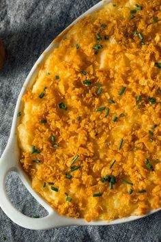 a casserole dish with cheese and parsley on the side, ready to be eaten