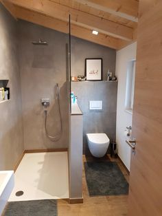 a bathroom with a toilet, sink and shower in it's center wall next to a window