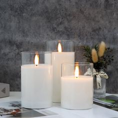 three white candles sitting on top of a table