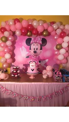 a minnie mouse birthday party with balloons and decorations