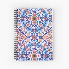 a spiral notebook with blue and orange designs on the front, featuring an intricate design