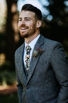 a man in a suit and tie smiles at the camera