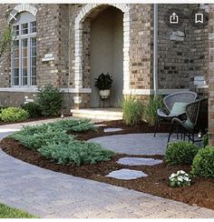 a brick house with landscaping around the front door and walkway leading up to the entrance