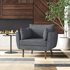 a living room with a chair, table and potted plant on the floor next to it