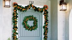 a front door decorated with oranges and greenery