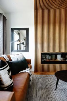 a living room filled with furniture and a fire place next to a wall mounted tv