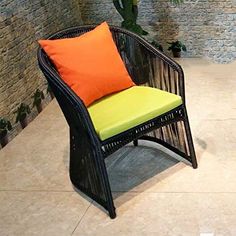 a chair with an orange and green pillow on it