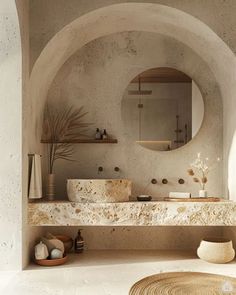 a bathroom with a circular mirror above the sink and two sinks in front of it