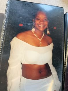 an old photo of a woman in white with pearls on her necklace and wearing earrings