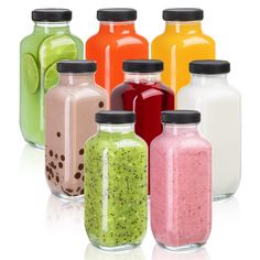 there are many different types of smoothies in glass jars on the white background,