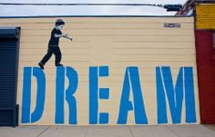 a mural on the side of a building that says dream with a skateboarder