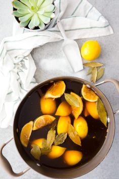 a pot filled with oranges on top of a table