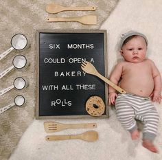 a baby is laying next to a sign that says six months could open a bakery with all these rolls